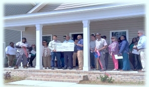A group of people standing on the porch of a house.