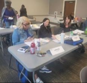 Tables of staff members attending a rent and income calculations class.