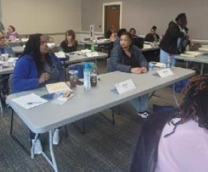 Several tables of staff members attending a rent and income calculations class.