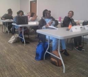 Multiple tables of staff members attending a rent and income calculations class.