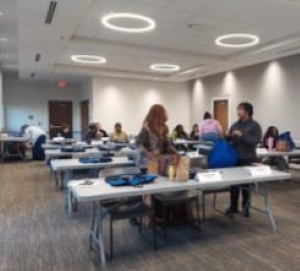 Multiple tables of assorted staff members attending a rent and income calculations class.
