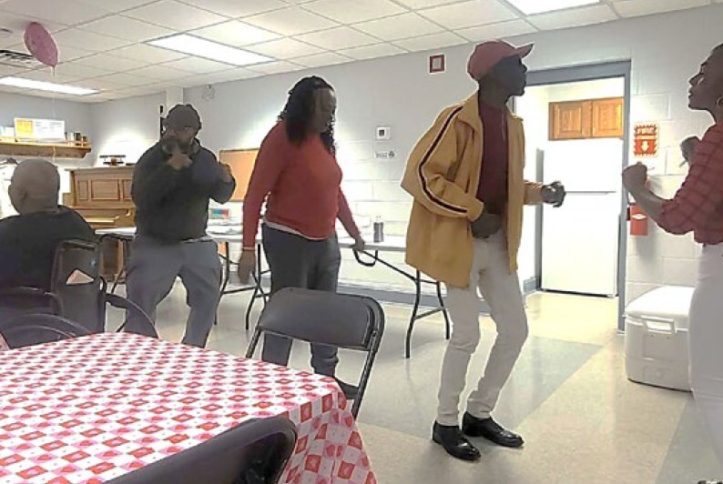 Four people in a line dancing.