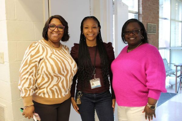 Three women smiling for a picture.