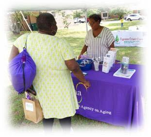 A woman talking to another woman at a table booth.