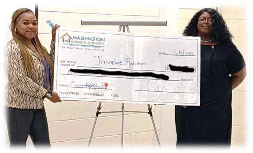 Jasmine Rodman and Margaretta Hines stand on either side of Jasmine's very large check.