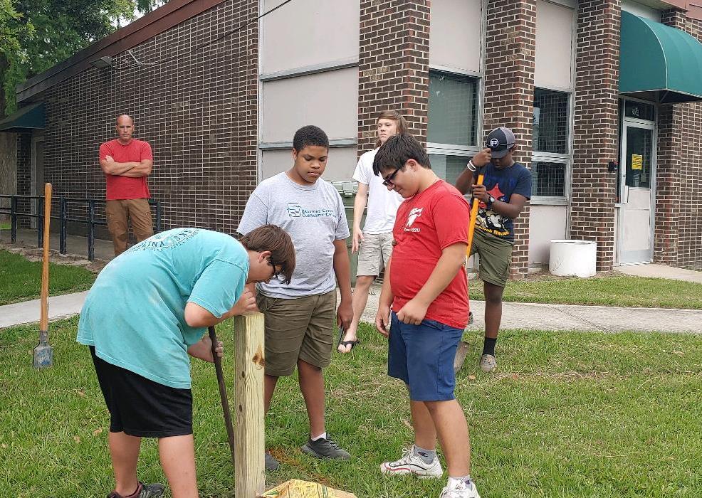 Members of The Eagle Scouts Troop 21 work together to install the little library.