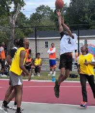 A person is in mid-air trying to dunk the basketball into the net.