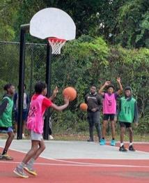 Basketball players on the sideline are cheering on their fellow teammates during the game.