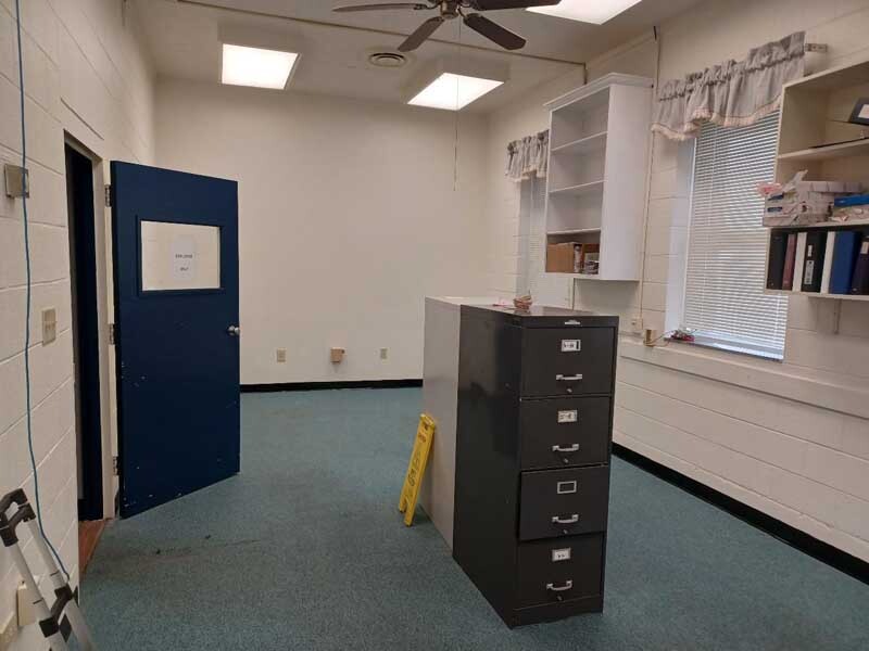 A filing cabinet sits in the middle of a room that is being renovated. 