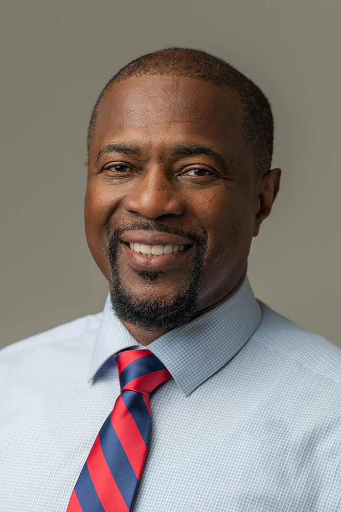 Michael Best, Executive Director, smiles for his headshot. 