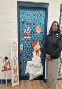 A woman standing in front of decorated door.