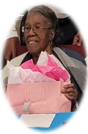 A woman smiles while holding a gift.