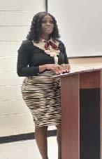 A woman standing behind a podium wearing a skirt.