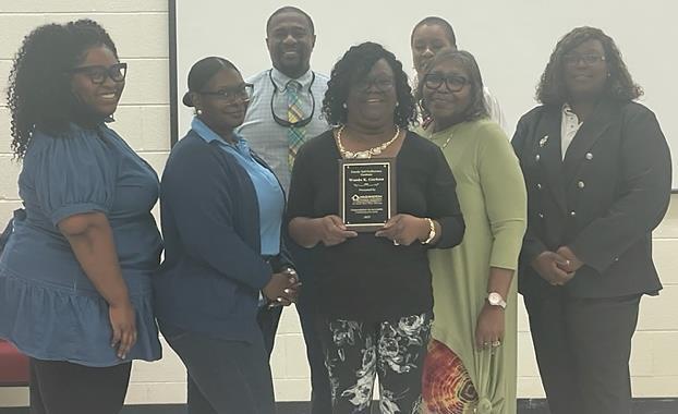 A group congratulating a woman on her award.