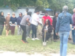 Group gathering for a photo with groundbreaking shovel.