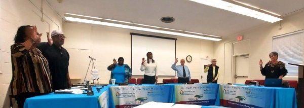 A group of people with their hands raised while swearing under oath.