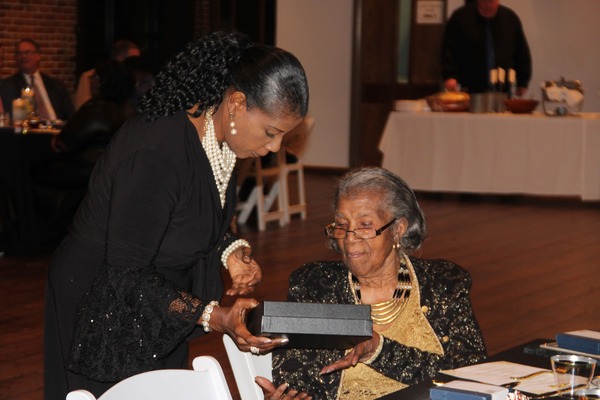 Ms. Royster looking at her plaque