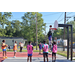 Guy in purple jersey hanging on to the rim after dunking a ball