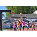 Kid in pink jersey shoots his shot while two kids in orange jerseys attempt to block it