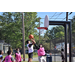 Young man in a pink jersey attempts to block white jersey's shot