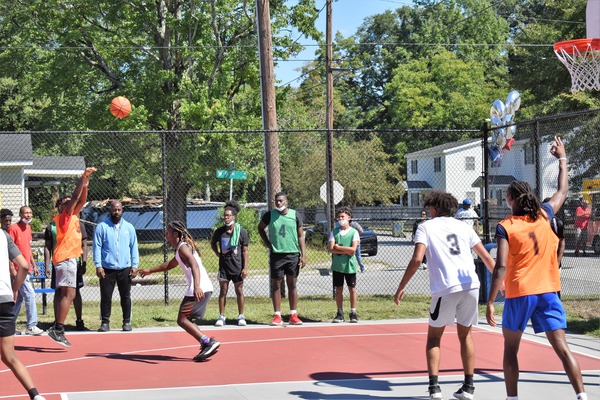 Guy in orange jersey shooting a 3 pointer