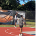 Young man in a gray shirt shooting from 3-point line