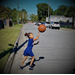 A little girl running and bouncing a ball