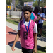 A young man in a pink jersey wearing his medal