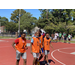 Four young men in orange jerseys walking on the court