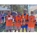 Four players in orange holding trophies