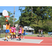 Players trying to stop kid from making a basket