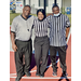 The three referees smiling at the camera