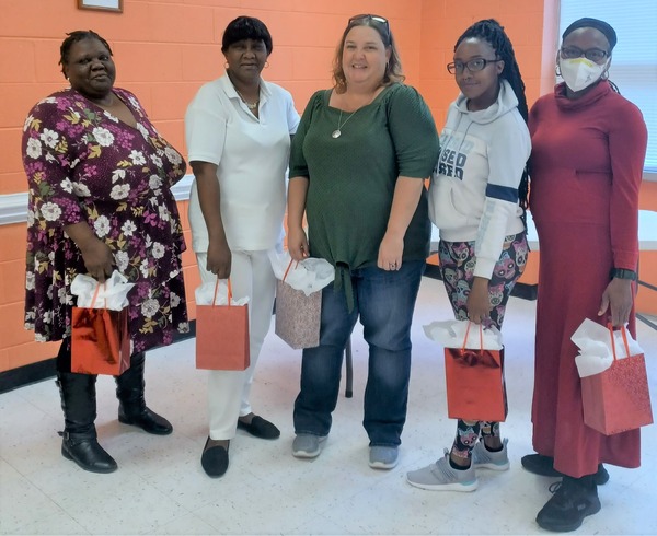 Five ladies holding gift bags