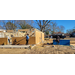 Construction workers standing around a house frame. 