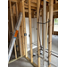 The interior view of the framing of the house and PVC pipe.