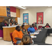 Students sitting at tables and listening to a presentation.