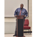 A man in a tie standing behind a podium.