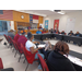 A side view of multiple students sitting at tables.