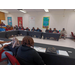 A wide view of a room of students sitting at tables.