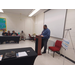 A man standing in front of a projector screen.