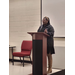 A woman wearing boots stands behind a podium.