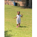 A child runs in an open yard.