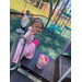 A child smiles with her basket full of eggs.