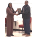 A man and woman shaking hands while accepting an award.