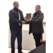 A woman and a man shake hands while accepting an award for graduating. 