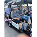 Two individuals sitting in golf carts.