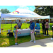 A group of people talk under a tent.