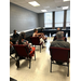 Members of a crowd sitting in chairs.