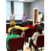 Three men stand at the head of a meeting room.