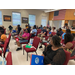 A large group of people sit in chairs.